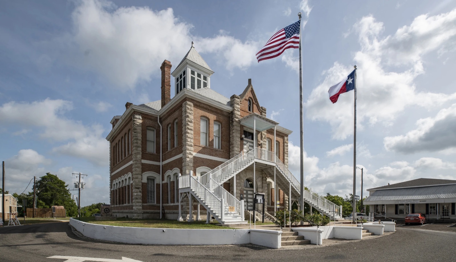 The Grimes County Courthouse in Anderson, Texas, with its exterior stairs and the U.S. and Texas flags